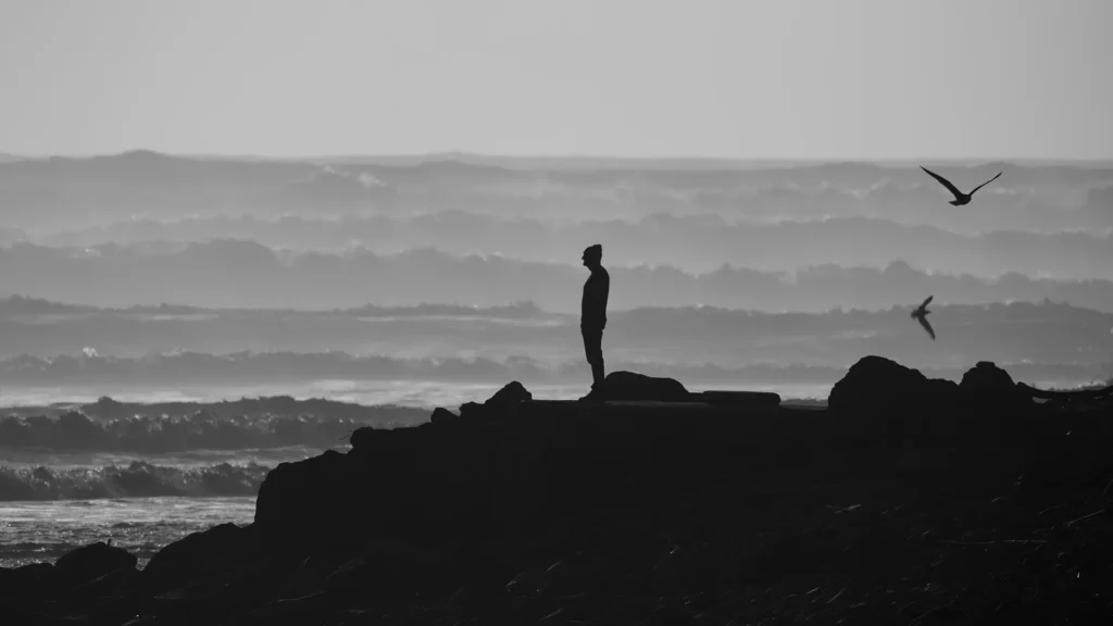 Silhouette d'un homme seul face à l'océan, symbolisant le deuil périnatal vécu par les pères